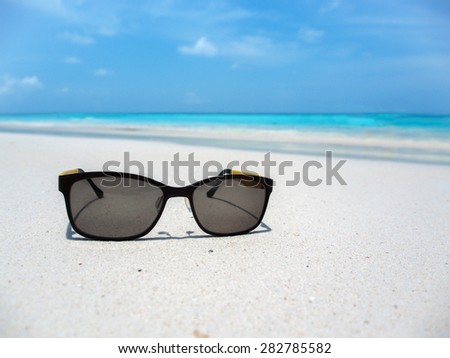 black glasses on the beach with shallow depth of field
