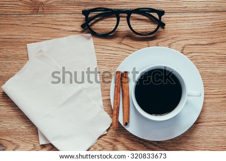 above view of coffee cup with glasses and tissue paper in vintage style