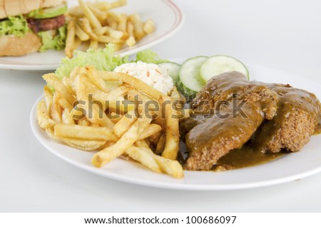 Western food-view of chicken chop set with burger and french fries on background.