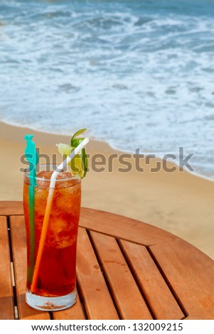 Americano cocktail with ice on the table against the background of sea and sky