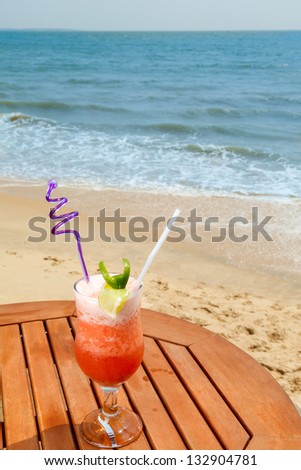 banana daiquiri cocktail with ice on the table against the background of sea and sky
