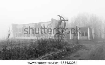 destroyed centre for social and cultural activities and a statue of Soviet citizens in the early morning fog in Russia, Kotelnich