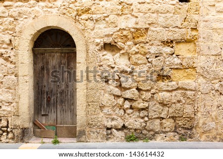 old wooden front door to the house and wall in the Mediterranean