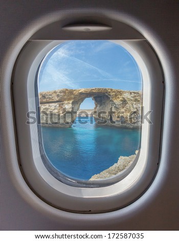 Azure Window, famous stone arch of Gozo island through the window of the plane against the blue sky on a clear day, Malta