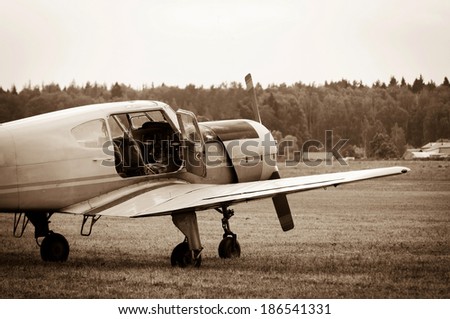 piston training aircraft on the ground with an open door to the cockpit