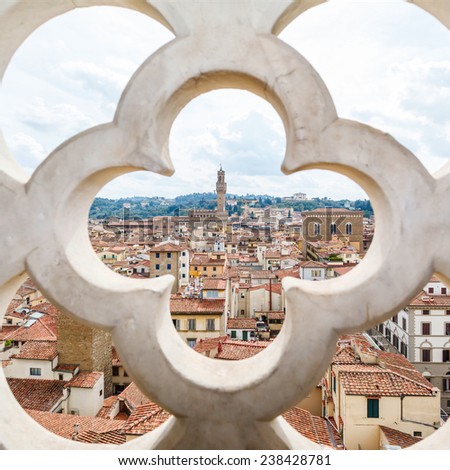 roofs, red tiles and narrow streets through the fence ornament bell tower in Florence, Italy
