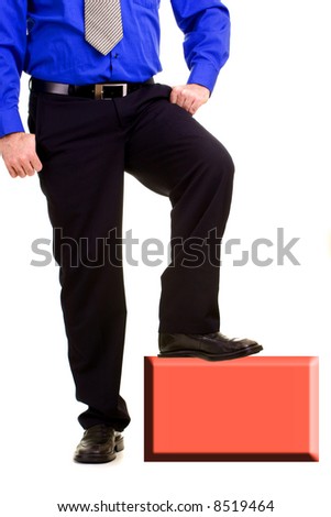 Young businessman standing on a small object.