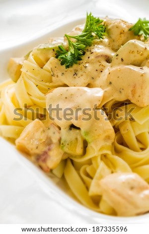 Close-up studio shot of Penne Chicken Alfredo in rich creamy sauce. Ideal for blog and recipe books