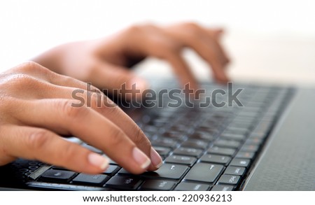 Close-up female hands typing on laptop.