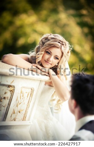 The bride on a background of nature listens playing the piano
