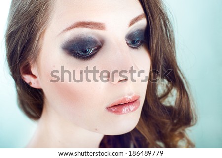 Close up portrait of beautiful young woman with dark evening make up