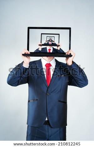 Portrait of a young man holding notebook in front of his face; repetitive picture on the screen
