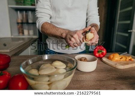 Similar – Image, Stock Photo Unrecognizable chef peeling potato in kitchen