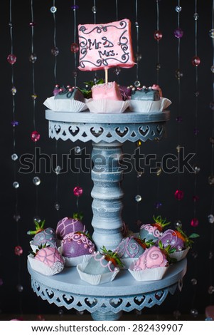 Variety of fruits (strawberry, banana, grape, pineapple) covered with a color chocolate and nuts, decoration of  wedding party table