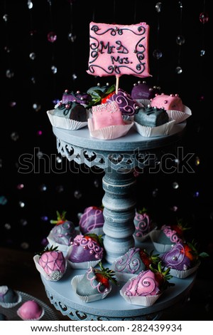 Variety of fruits (strawberry, banana, grape, pineapple) covered with a color chocolate and nuts, decoration of wedding party table