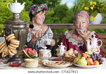 Two women drinking tea outdoors. Kustodiev Russian artist style, beginning of the last century