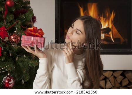 Pretty young woman think about her Christmas gift box