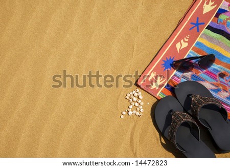Beach towel and shoes on the sand