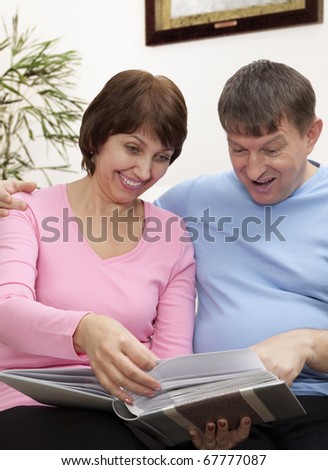 Elderly couple look a photo album at home