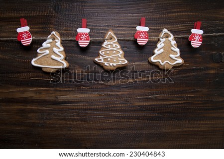 Christmas background with cookies decorated with icing, with clothespins - gloves     on a wooden board.