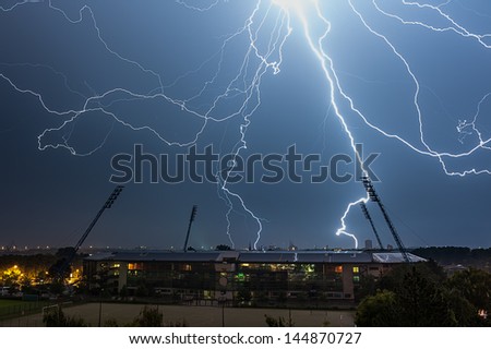Thunderstorm above a Stadium, in the background is the Skyline of the City Rostock