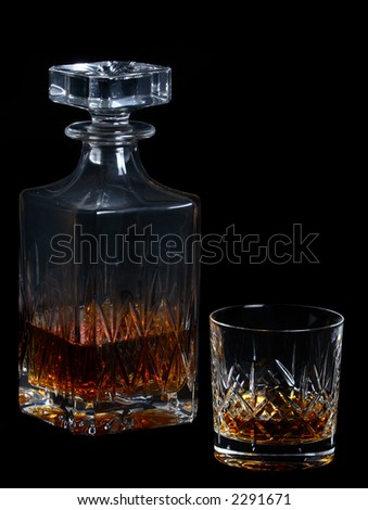 Whiskey bottle and whiskey (tumbler) glass on a black background
