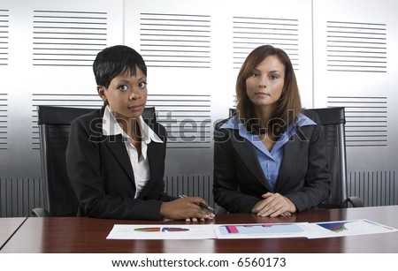 Multi-racial business team working within an office with a sales graphs