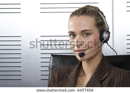 Young blond call center agent talking on the headset in a modern office setting