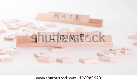 Love Hate concept spelled in Scrabble letters on white background