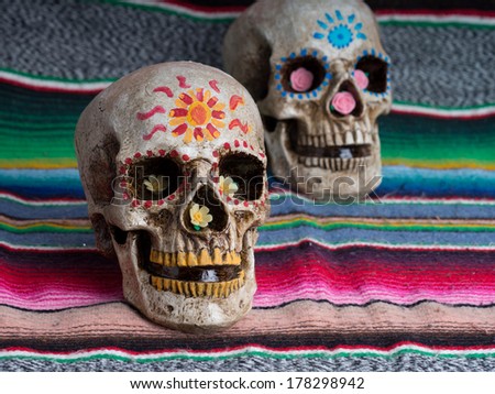 Day of the Dead (dia de los muertos) decorated skulls with colorful Mexican blanket