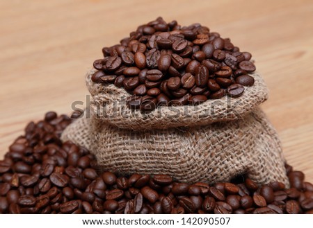 coffee beans in a burlap bag on a wooden table