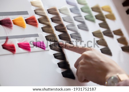 View of Woman Choosing Color from the Hair Color Chart  For Hair Dye Concept