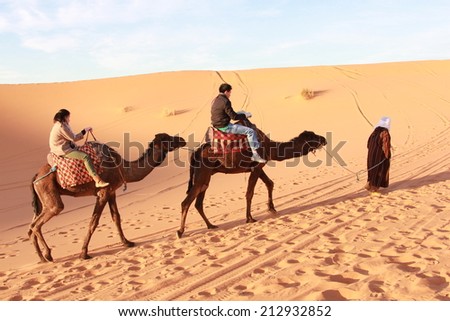 SAHARA, MOROCCO - DECEMBER 7, 2012:Unidentified group of people riding camel in Sahara Desert in Morocco on December 7, 2012.