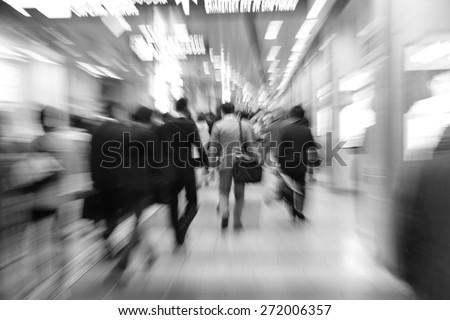 businesspeople walking in motion blur in a corridor