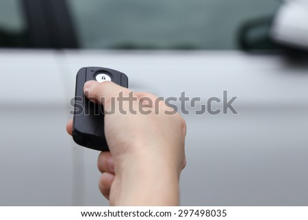 close up on a hand using car key to open the car