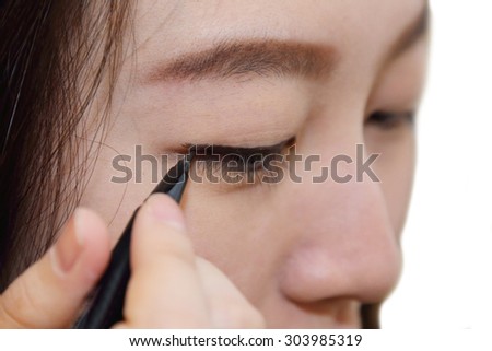 isolated asian woman use cosmetic brush to draw her eyebrows