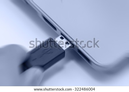motion blur image of hand connecting usb 2.0 to laptop usb port