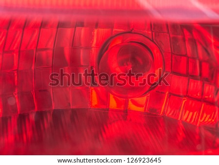 A close-up of the brake light from the rear of a car.