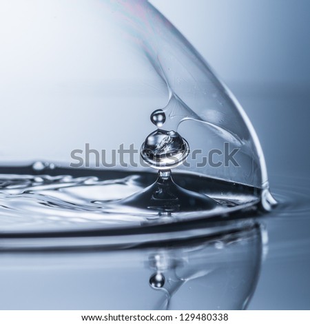 A water drop breaks through a bubble.