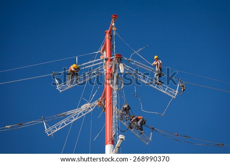 Workers repairing a high voltage industrial power energy line. Great for energy, safety and technology themes.  : Almada, Portugal - October 02, 2008