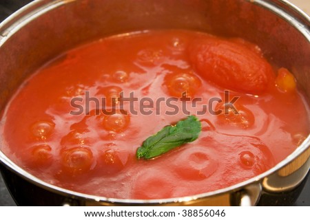 cooking tomato sauce with basil twig
