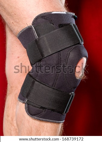 Closeup of a man legs with one knee in a protective knee brace