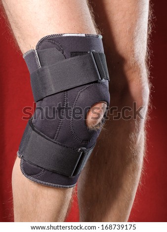 Closeup of a man legs with one knee in a protective knee brace