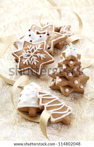 Christmas background. Ginger and Honey cookies with white sugar decoration and gold ribbons.