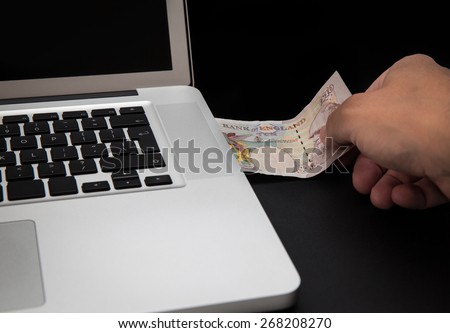 Cyber theft concept shot with laptop and money
