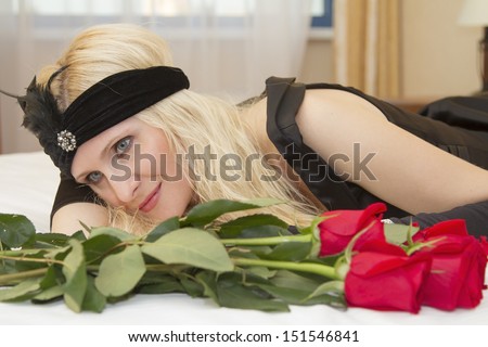 The girl in a black dress with an ornament on her head and red roses