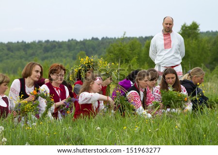 TALTSY, RUSSIA - JUNE 22: Belarusian girls in the Irkutsk region gather flowers and making wreaths during the celebration of the ancient pagan festival Kupalle June 22, 2013 in Taltsy, Russia