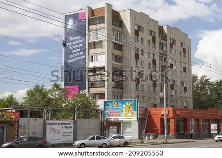 OMSK, RUSSIA - JULY 2: Busy street and house in the city of Omsk on July 2, 2014 in Omsk.