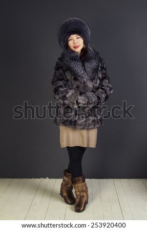 Cute girl oriental appearance in a fur coat and hat from the silver fox