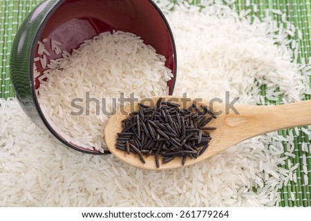 Plate with white rice and wooden spoon with black rice